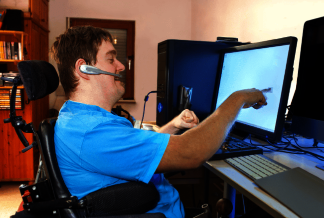 Mann im Rollstuhl spielt am Computer